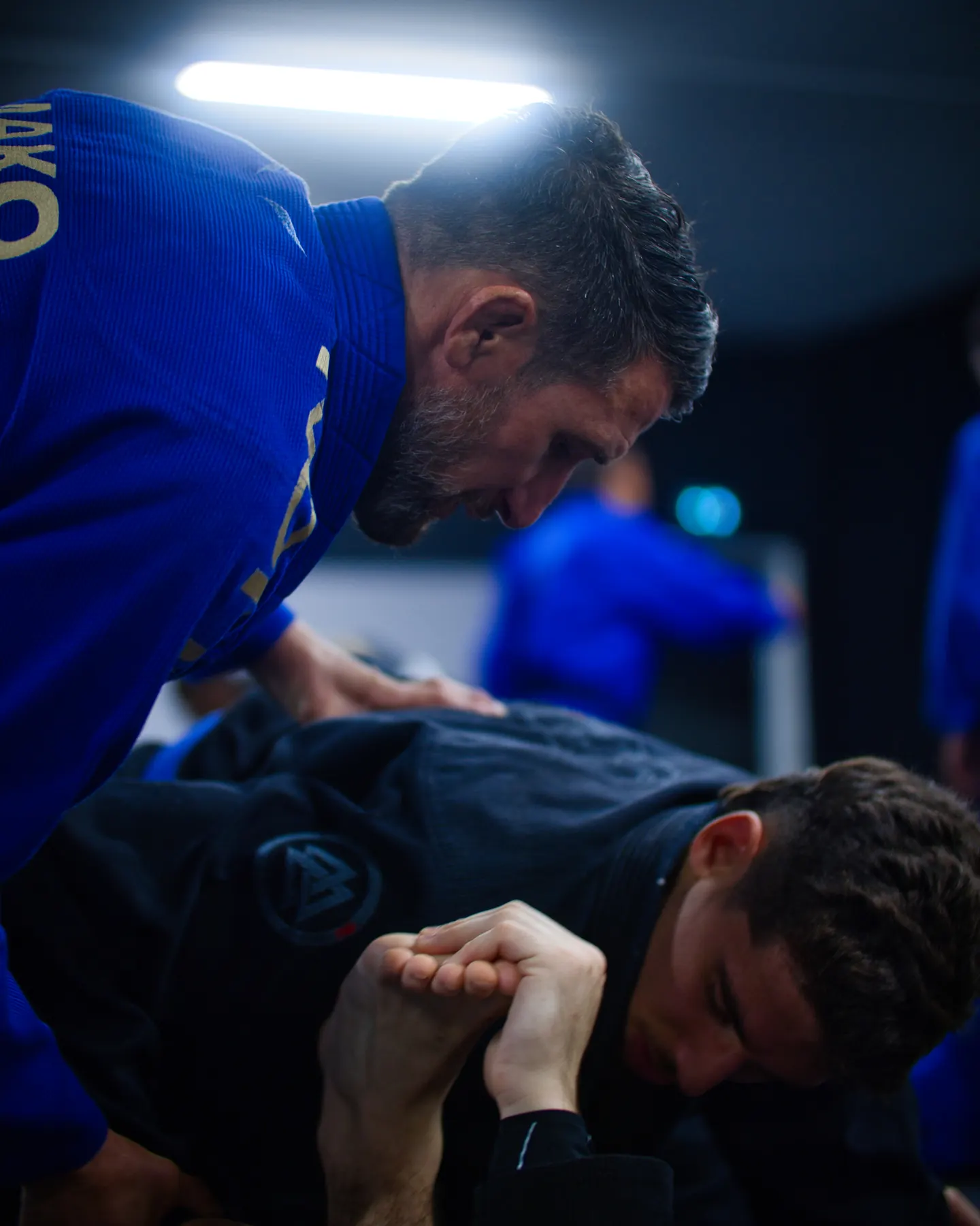 Un coach penché sur un élève pour corriger une prise