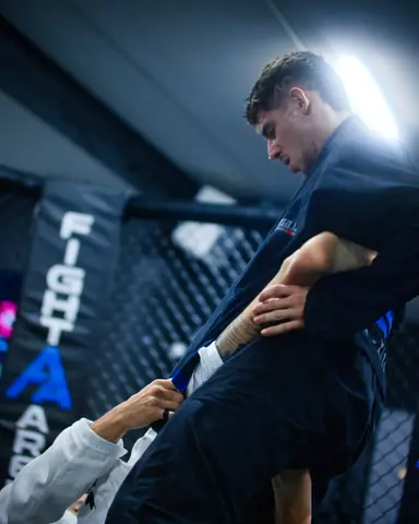 Passage de garde en kimono sombre près de la cage Fight Arena